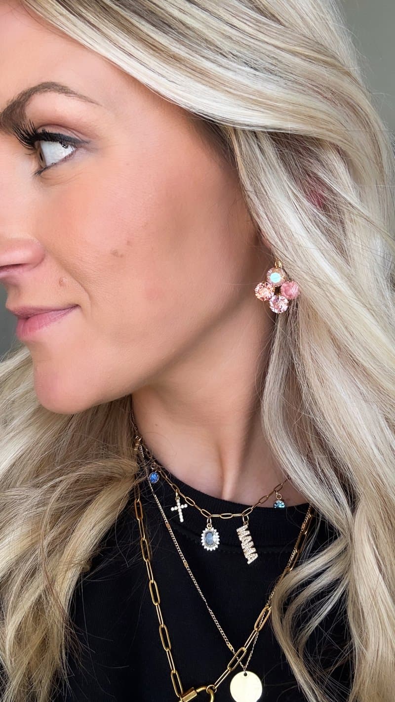 Pink crystal stud earrings and gold layered necklaces closeup