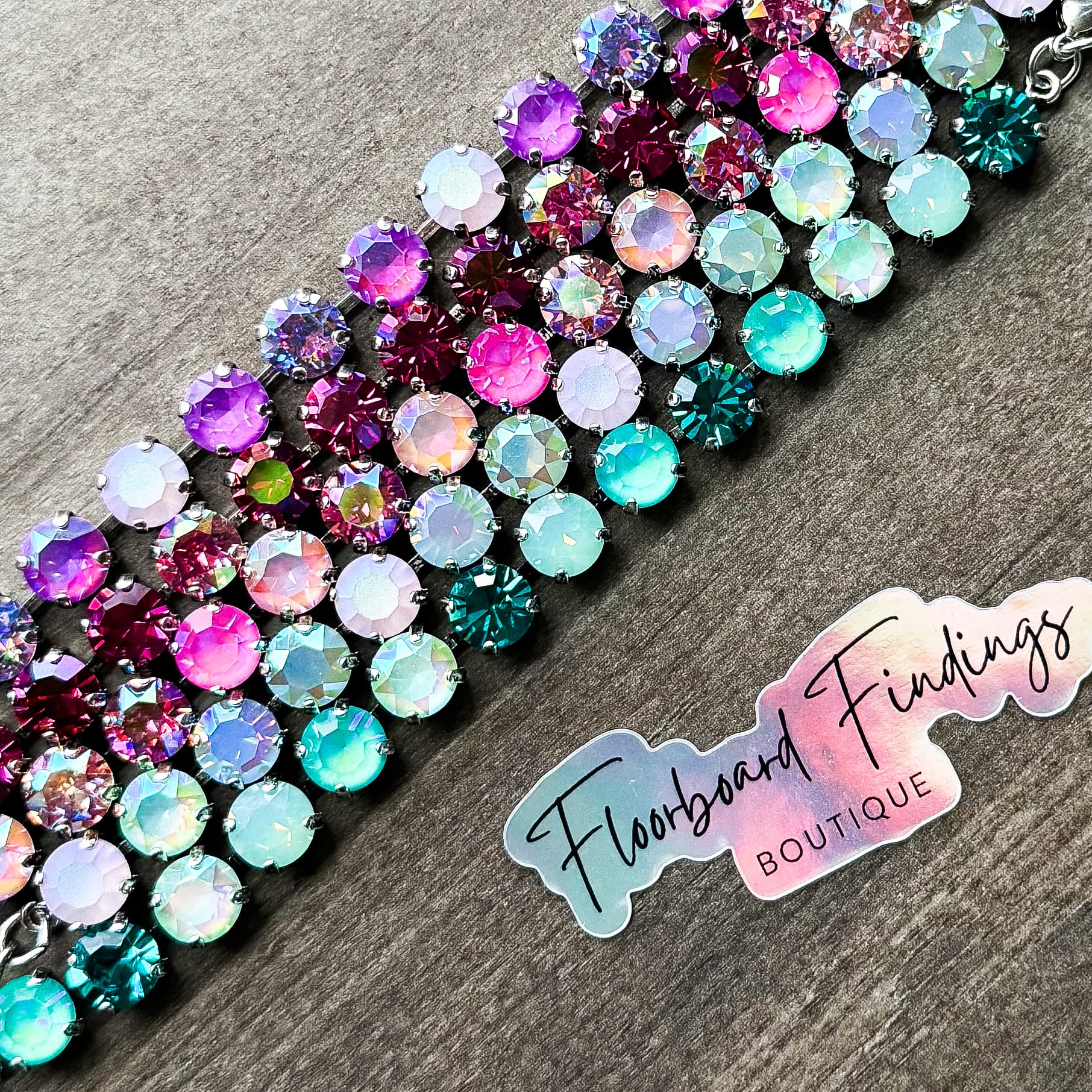Multi-row Swarovski crystal bracelet in purple, pink, and teal with Floorboard Findings branding