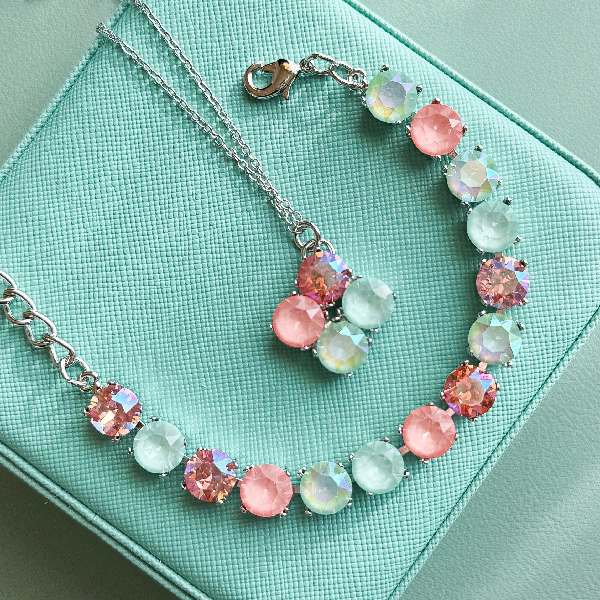 Pastel pink and mint Swarovski crystal cup-chain necklace on teal jewelry box