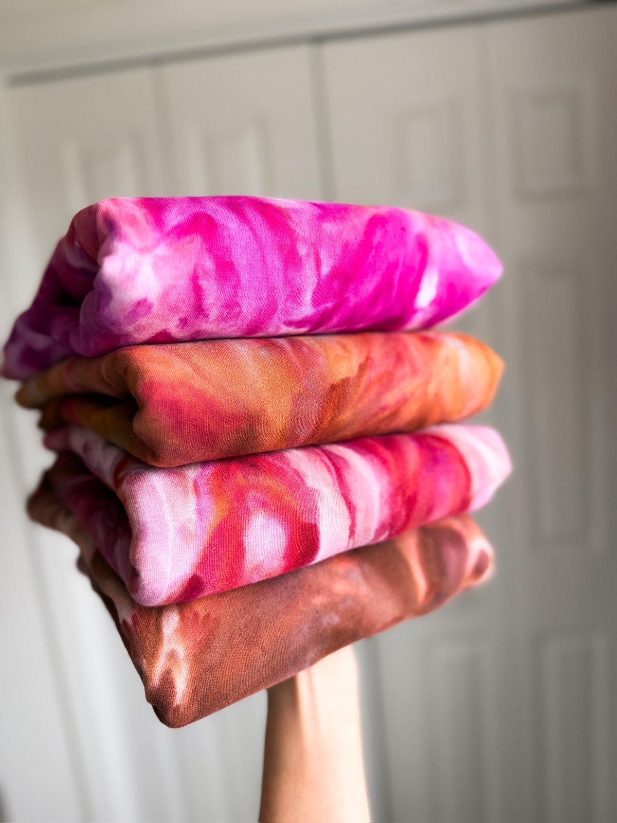 A stack of hand ice-dyed pieces, each one different